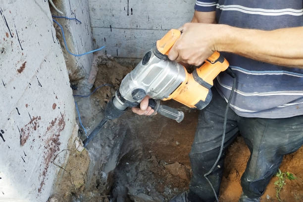 istock The master performs dismantling by a punch, dashes a cable niche in the wall. 2086120717