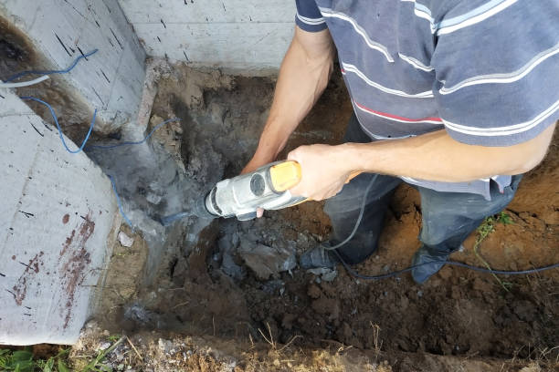 istock The master performs dismantling by a punch, dashes a cable niche in the wall. 2086121775