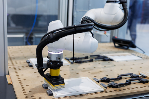 An automated robotic arm polishing a wooden surface. High-tech industrial production
