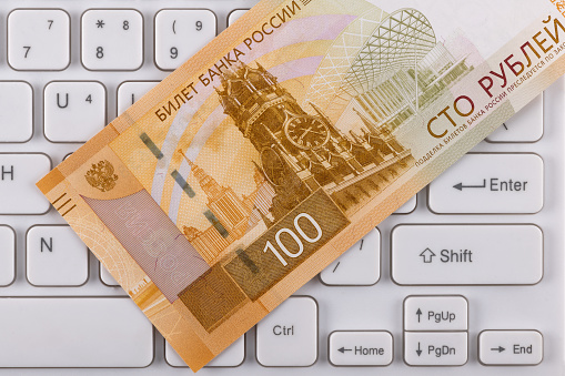Banknote of 100 Russian rubles on a computer keyboard