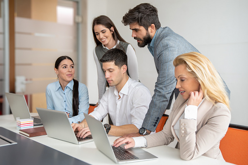 Group of confidence business people working together in the office on laptop computers