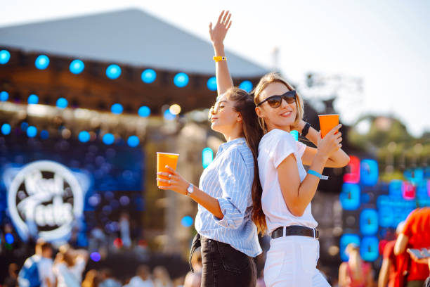 istock Two young woman with beer at beach party. 2086173597