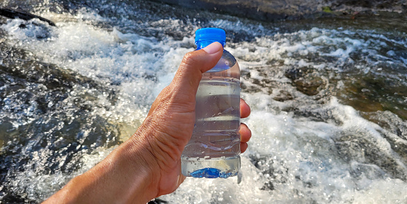Mineral water in the bottle with stream background.