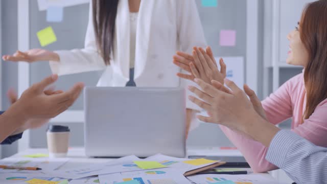 Close up hand of young businessman and businesswoman clapping together. Attractive employee worker feel happy, motivate each other and work as unity teamwork to discuss project in corporate