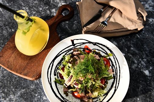 Restaurant prepared mixed salad on table for lunch, dinner or small party with lemonade at the side