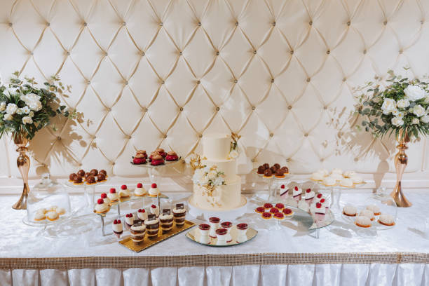 istock A delicious wedding. Beige cake decorated with flowers. Candy bar with various chocolate sweets. Celebration concept. Fashionable desserts. Table with sweets, candies. 2086234821