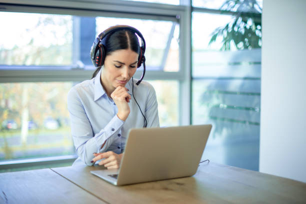 istock Concentrated business woman helpdesk operator using laptop at modern office. 2086244692