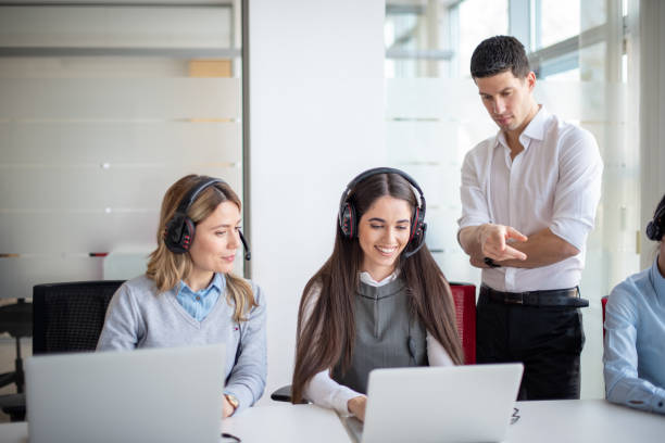 istock Call center manager, mentor or coach giving advice and helping team while reading feedback on computer. 2086250023