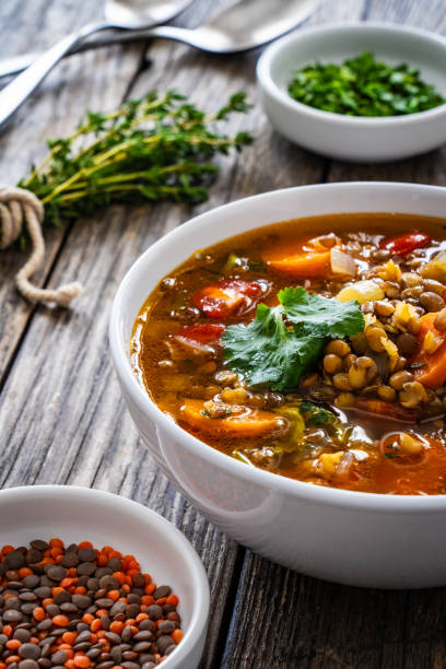 istock Fresh vegetable soup with lentil on wooden table 2086263121