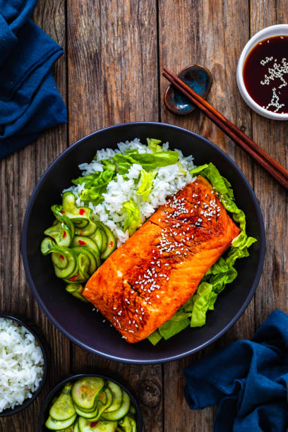 istock Seared teriyaki salmon steak with white rice on wooden table 2086264777