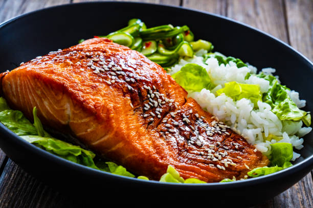 istock Seared teriyaki salmon steak with white rice on wooden table 2086265473