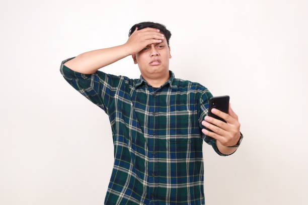 istock Scared young asian man touching his head while holding a cell phone 2086265839
