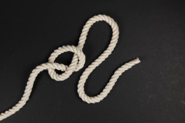 rope with a knot on dark background - fotos de ahorcamiento fotografías e imágenes de stock