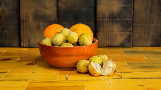 Fruits containing vitamin C in a bowl made of wood