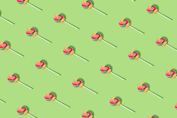 Trendy pattern made of colorful lollipops on light green background. Minimal layout. Creative candy concept. Colorful sweet food background.