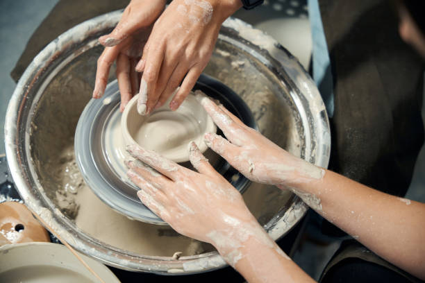 istock Unrecognizable women making clay jug sculpting in workshop on potter's wheel 2086308529