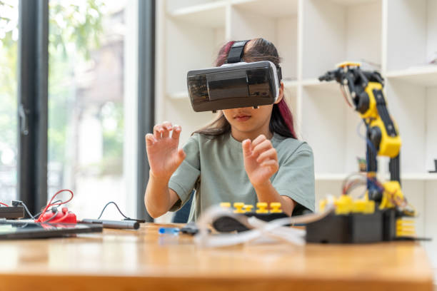 istock Young girl wearing VR headset and moving her hands around to work on her virtual robot assembly 2086311230