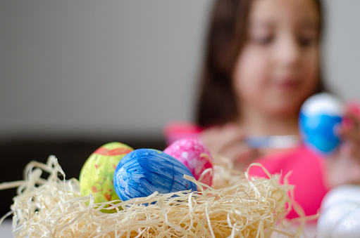 Girl painting eggs for Easter celebration.