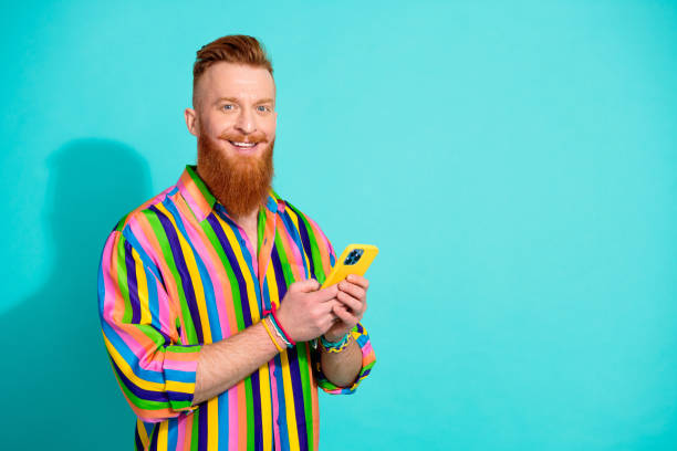 Photo advertisement of new apple iphone 15 pro max version young bearded guy testing modern gadget isolated on cyan color background