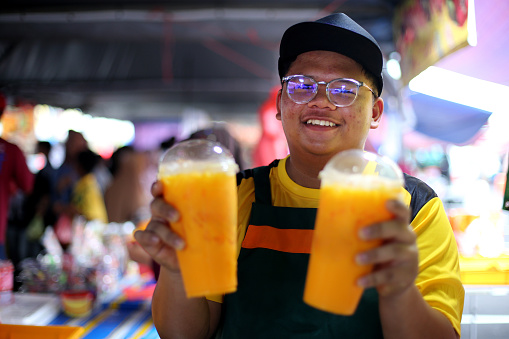 A Muslim young man showing corn milk drink selling at street bazaar