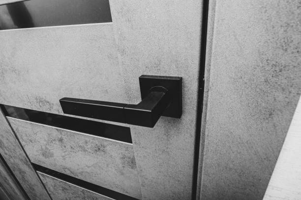 black handle on a gray ajar door close-up