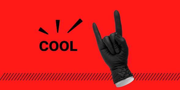 Hand in black rubber glove shows  Heavy metal or devil horns gesture next to inscription COOL on red background. Minimalist art collage