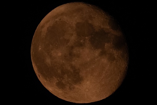 The full moon, deep red in color, during partial eclipse.