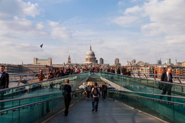 Millenium Bridge with many pedestrians crossing on a sunny day