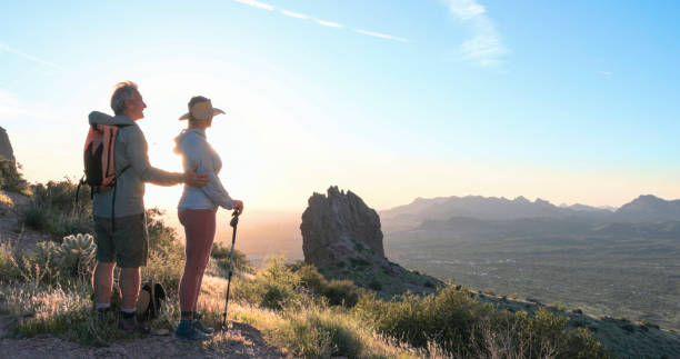 istock Hikers watch sunset over desert 2086389698
