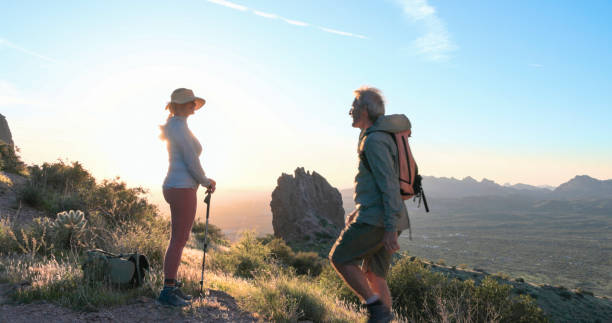 istock Hikers watch sunset over desert 2086389714