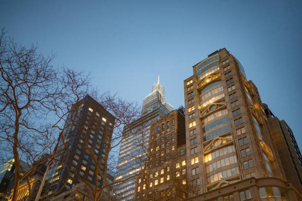 This photograph is of the illuminated skyscrapper buildings surrounding Bryant Park in Manhattan at dusk on a spring evening.