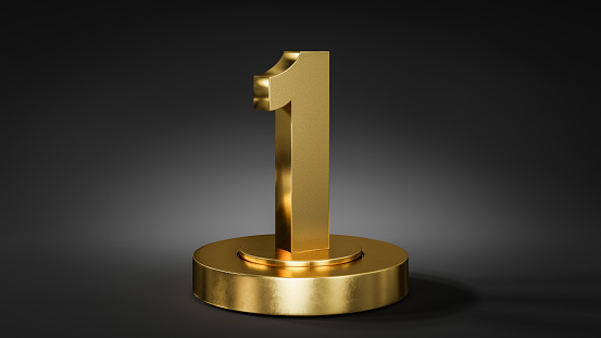 The number 1 on a pedestal / podium in golden color in front of dark background with spot light.