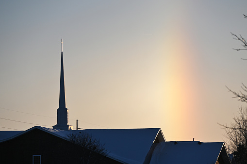 Winter rainbow behind Christian church.