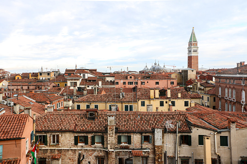 Great view of St Marks Campanile (Bell Tower) towering above the residential buildings of Venice with their typically tiled roofs - Venice, Italy