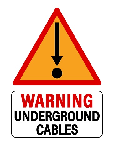 Warning underground cables. Orange triangle sign with arrow symbol pointing down to a circle, symbol of cable cross section. Text below.