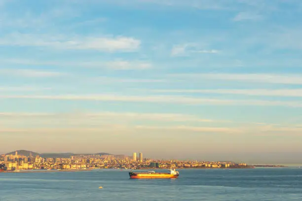 Photo of Cargo ship moving through Bosphorus during sunset.