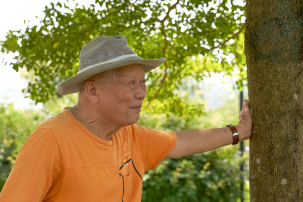 An old Asian man is happily visiting the park