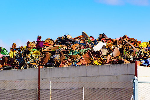 Huge pile of scrap metal junk garbage with blue sky background