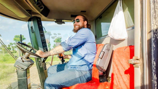 istock Man and a combine harvester. 2086534267