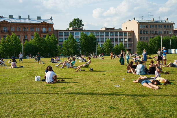 St. Petersburg, Russia - July 07, 2012: People resting on the lawn in the New Holland Island park