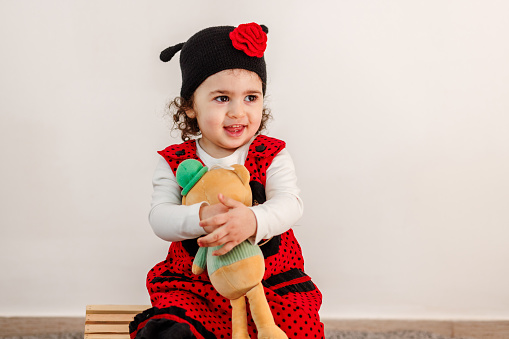 A child s delightful interaction with a stuffed animal, celebrating Easter in a ladybug costume.
