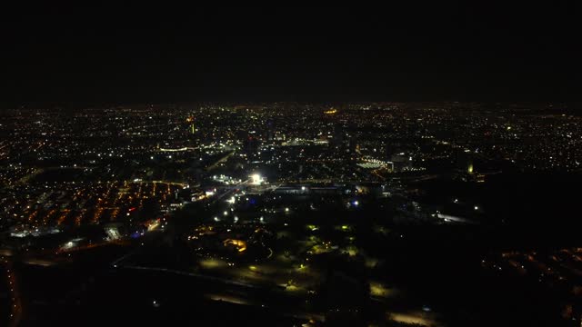 Lighting Cityscape of Puebla City at night in Mexico. Aerial birds eye flyover.