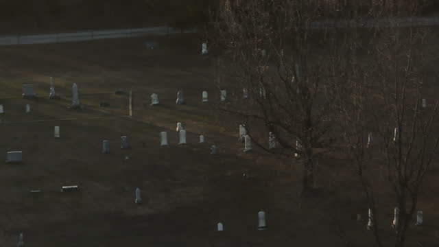 Headstones At Graveyard Near Lake Swepco In Arkansas, USA. drone tilt-up shot