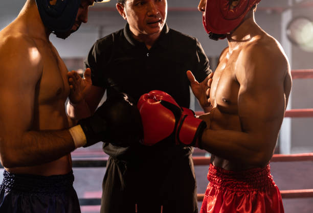 istock Boxer fighter with safety helmet face off with each other while referee. Impetus 2086632429