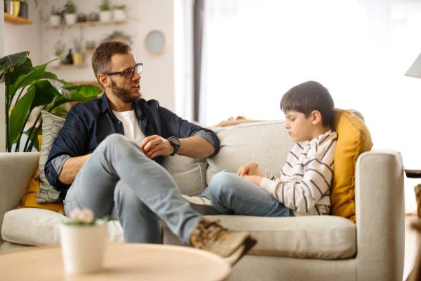 istock Father and son sitting on the sofa and sharing food 2086641262