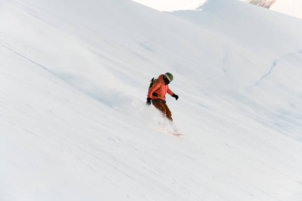 istock Top view of a snowboarder going down a steep snowy slope on his snowboard 2086667100