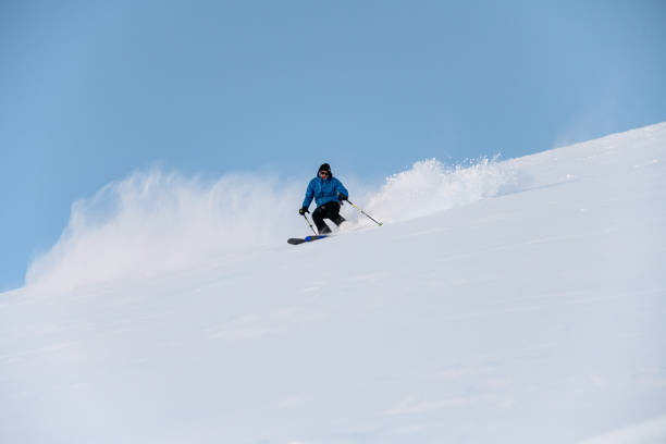 istock Skier with poles in his hands goes down a snowy slope 2086678269