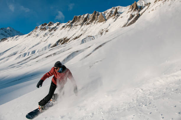 istock Snowboarder maneuvers down the slope on his snowboard 2086708902