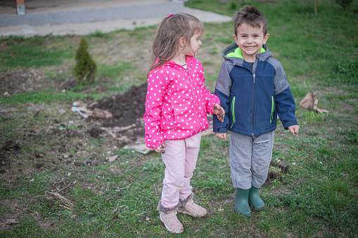 Portrait of smiling small children outdoors, back yard