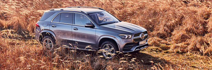 Luxury Mercedes GLE 450 with 4x4 on a dirt road through a meadow. V6 engine, 367 hp. Orzesze, Poland - 01.12.2020